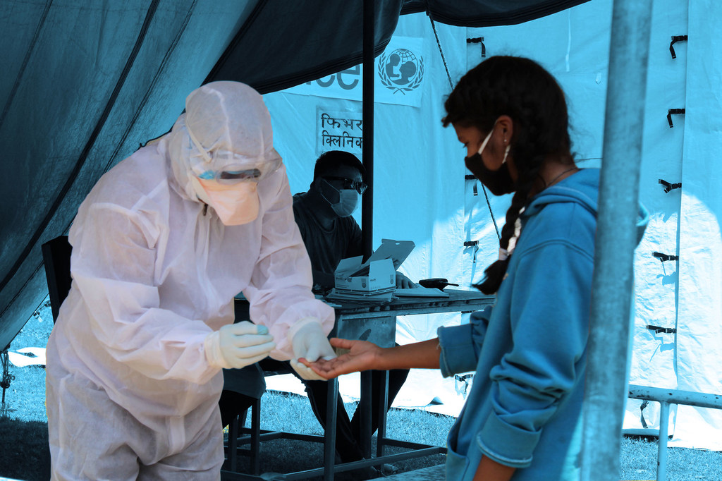 Photo : UNICEF/Népal Un agent de santé effectue un dépistage de la Covid-19 chez une jeune fille dans une clinique installée à côté d'un hôpital du district de Saptari, au Népal.