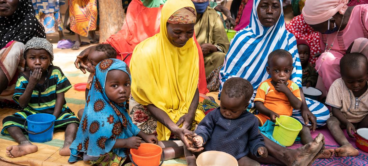 © WFP/Evelyn Fey Une mère nourrit son enfant lors d'une séance de sensibilisation à la nutrition au Niger.