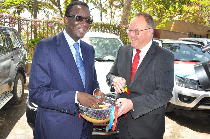 Amadou Bâ, ministre de l’économie et des finances recevant les clefs des voitures des mains de  Monsieur Romain Shneider, ministre de la coopération et de l'action humanitaire