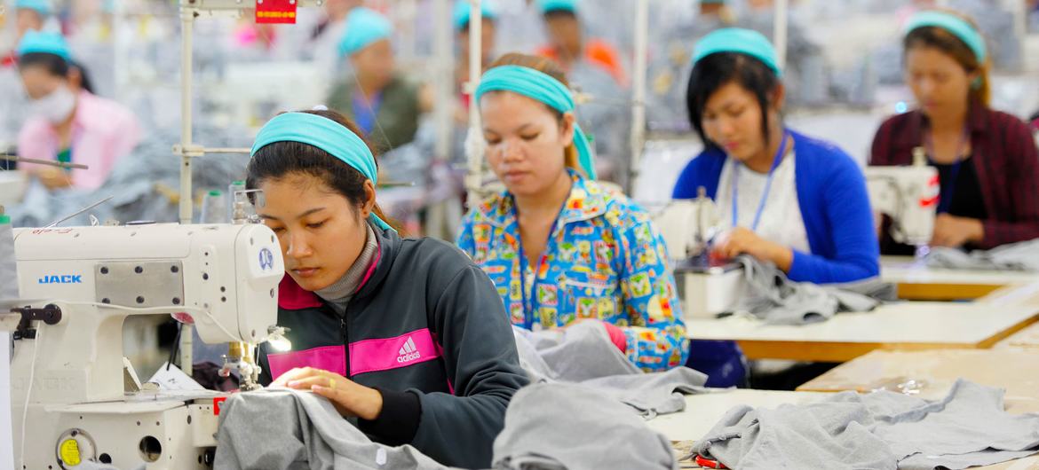 © ILO/Marcel Crozet Des tailleurs travaillent sur une chaîne de production dans une usine de vêtements au Cambodge.